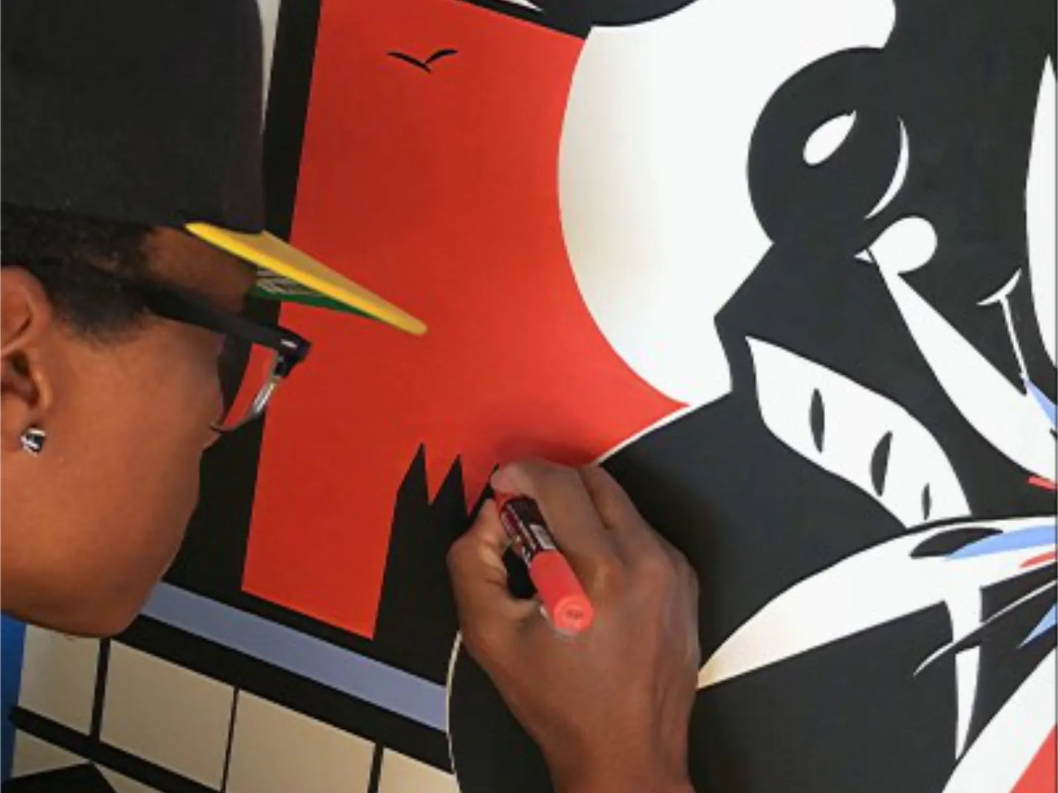 Close-up of the artist creating with faces, birds, and shapes guided by memory and instinct.