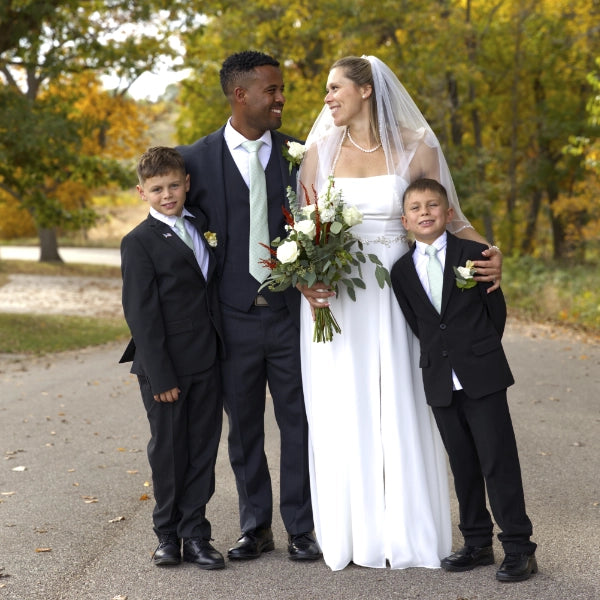 Wedding couple with two children outdoors in a park setting