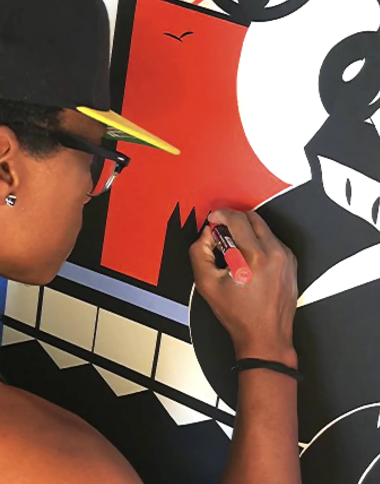 Mack bo ross drawing on a large poster with a red marker