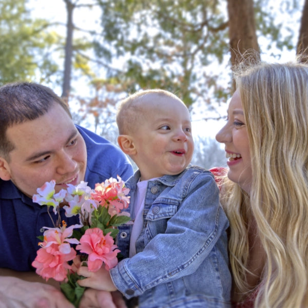 Family with a child holding flowers in a park setting