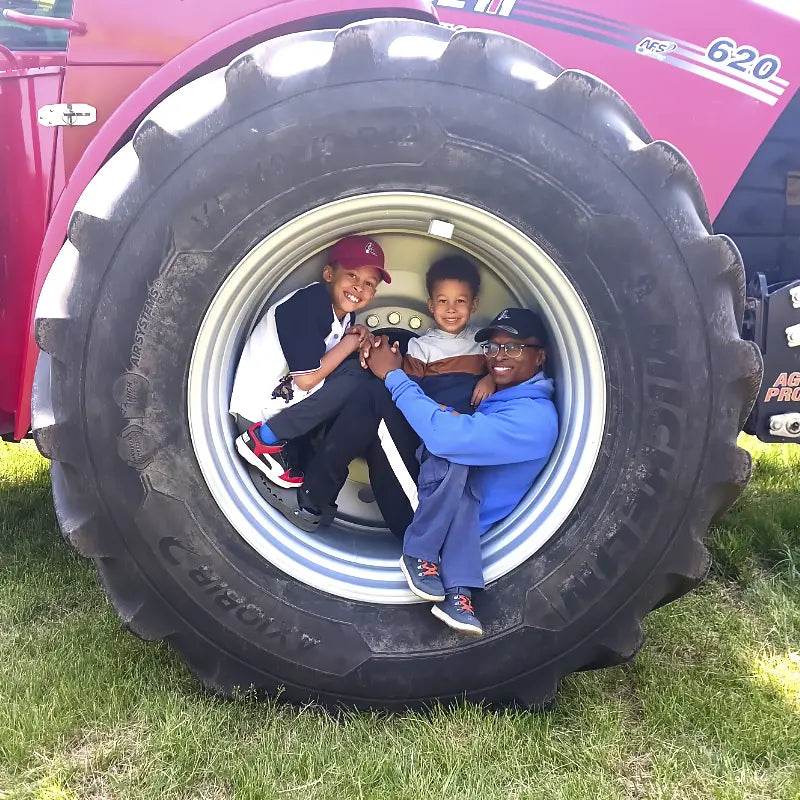 Artist with children sitting in tractor tire at Wisconsin dairy breakfast farm event