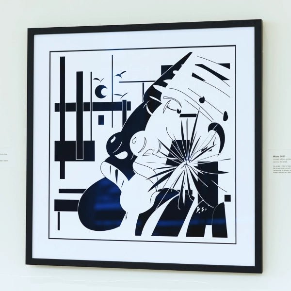 Framed abstract artwork with black and white design on a white wall