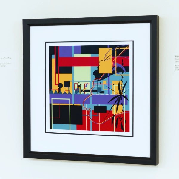 Framed abstract artwork with colorful geometric design on a white wall